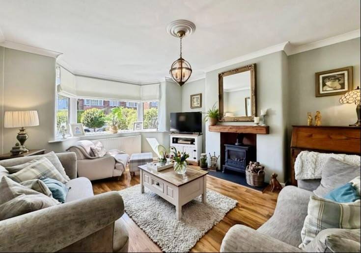 Living room with a bay window and log burner